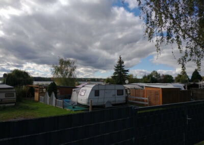 Süßer See - kleiner Blick hinter den Sichtschutz auf den Campingplatz mit Wohnwagen