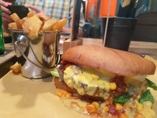 Burgerrestaurant Mampfy - im Vordergrund Chili Cheese Burger, links daneben Zinkeimerchen mit Pommes